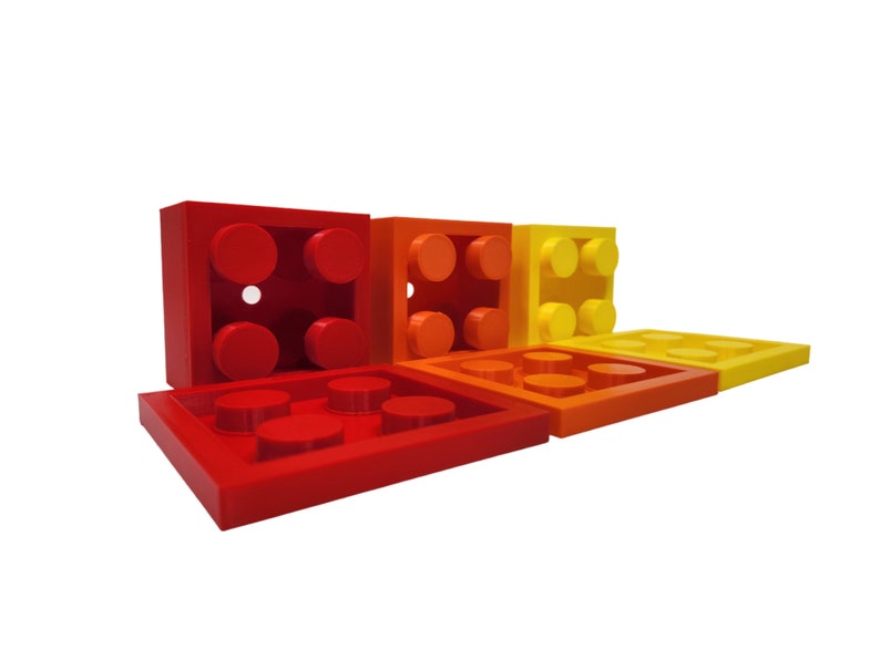 May include: A set of five red, orange, and yellow plastic building blocks. The blocks are arranged in a row, with the largest block on the left and the smallest block on the right.