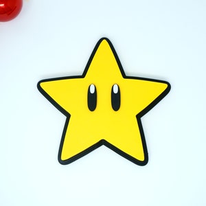 May include: A yellow star with black outlines and white eyes. The star is a popular video game character.