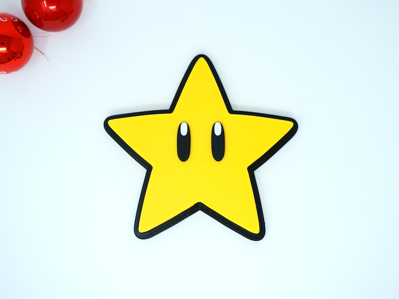 May include: A yellow star with black outlines and white eyes. The star is a popular video game character.