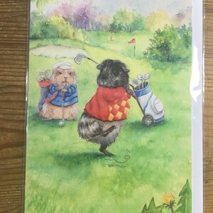 ゴルファー、モルモットのグリーティングカード。タンポポに気を取られていると、完璧なショットを打つのは難しいですね！