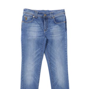 Puede incluir: Vaqueros de mezclilla azul claro con un diseño clásico de cinco bolsillos. Los vaqueros tienen cierre de botón y cremallera, trabillas para el cinturón y un pequeño detalle de logotipo en el bolsillo delantero. La mezclilla tiene un lavado descolorido y una sutil angustia.