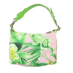 K&ouml;nnte beinhalten: Eine rosa Umh&auml;ngetasche mit gr&uuml;nem Blumenmuster und einem leuchtend gr&uuml;nen Riemen. Die Tasche hat eine Vordertasche und silberfarbene Beschl&auml;ge. Das florale Design umfasst gr&uuml;ne Bl&auml;tter und wei&szlig;e und gelbe Bl&uuml;ten.