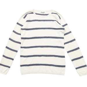 May include: Cream-colored long-sleeved sweater with horizontal navy blue stripes. The sweater has a crew neck and is made of a soft material. A casual, everyday top.