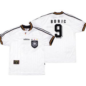 May include: White Adidas soccer jersey with black and gold trim, featuring the German national team crest and the number 9 on the back. The name "BOBIC" is printed above the number. The jersey has the Adidas logo and three stars.