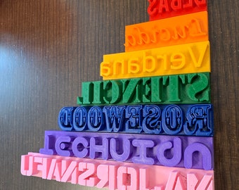 May include: A stack of colourful blocks with the words "AM", "YOUR", "JOY", "IN", "2", "1", "F", "A", "V", "E", "TECHUI", "WOOD", "ROSES", "STENCIL", "VERDANS", "INCUR", "BEBAS" printed on them.