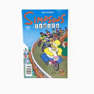 May include: A Simpsons Comics issue #166 cover featuring Homer Simpson riding a bicycle with a pink basket. The cover is blue with the title "Simpsons Comics" in yellow and black letters. The text "Holy Spokes!" is in white letters on a blue background.