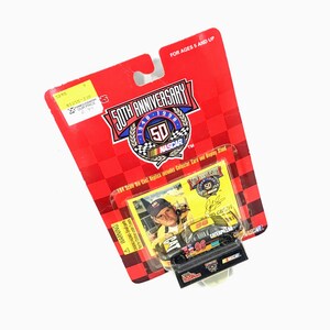 Puede incluir: R&eacute;plica de coche de carreras NASCAR 50 aniversario, empaquetada en una tarjeta roja y negra. El coche es negro, amarillo y naranja con el n&uacute;mero 96 y el logotipo de Caterpillar. Incluye una tarjeta de coleccionista.