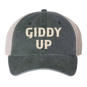 May include: A dark gray and white trucker hat with the text "Giddy Up" embroidered in a cream color.