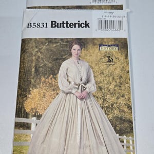 May include: Two Butterick sewing pattern envelopes. The top envelope is labeled B5831 and includes size information. The bottom envelope features a woman in a cream-colored dress. The dress has long sleeves and a full skirt. The History logo is visible.