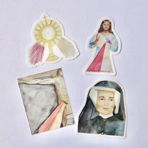 May include: Four watercolor stickers featuring religious imagery. The stickers depict a monstrance, Jesus Christ with the Divine Mercy rays, a depiction of the crucifixion, and a portrait of a nun. The stickers are printed on white paper.