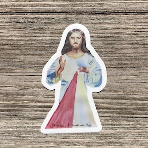 May include: A watercolor sticker of Jesus Christ with a red, white, and yellow heart radiating from his chest. The sticker has the text "Jesus, I trust in You!" at the bottom.