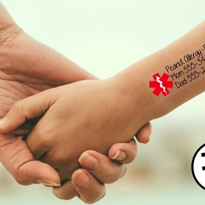 May include: A red medical alert sticker with a snake and staff symbol, the text "Peanut Allergy-EpiPen" and phone numbers for Mom and Dad. The sticker is on a child's wrist. The text "Temp Too" is visible in the lower right corner of the image.