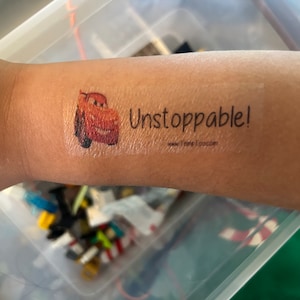 May include: A temporary tattoo featuring a red cartoon car with the words "Unstoppable!" in black text.