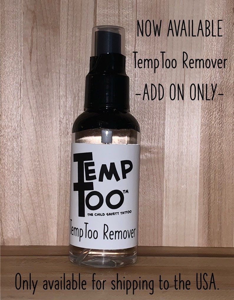 May include: A clear plastic bottle with a black spray nozzle and a white label that reads "Temp Too" and "The Child Safety Tattoo" with the text "Temp Too Remover" below. The bottle is on a wood surface. The text "NOW AVAILABLE Temp Too Remover -ADD ON ONLY- Only available for shipping to the USA." is visible above the bottle.