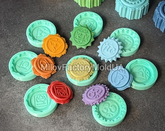 May include: A set of seven colorful silicone molds for making candles. Each mold features a different chakra symbol, including the root chakra, sacral chakra, solar plexus chakra, heart chakra, throat chakra, third eye chakra, and crown chakra. The molds are made of high-quality silicone and are easy to use and clean.
