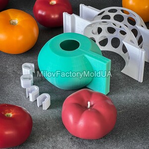 May include: A set of silicone molds for making candles in the shape of tomatoes. The molds are teal, white, and red. The text "MiloFactoryMoldUA" is visible on the teal mold.