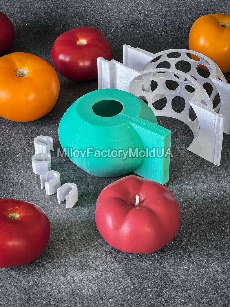 May include: A set of silicone molds for making candles in the shape of tomatoes. The molds are teal, white, and red. The text "MiloFactoryMoldUA" is visible on the teal mold.