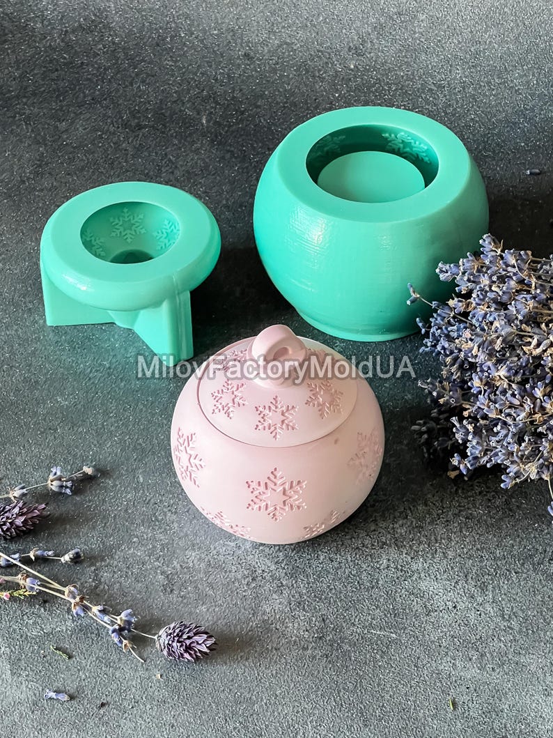 Pu&ograve; includere: Tre stampi in silicone per la realizzazione di candele. Gli stampi sono verdi e rosa. Lo stampo rosa ha la forma di un ornamento natalizio e presenta un motivo a fiocco di neve. Gli stampi verdi sono rotondi e hanno un bordo rialzato intorno alla parte superiore.