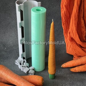 May include: A carrot-shaped candle in orange with a green base, alongside a green cylindrical mould and a grey mould. Fresh carrots and orange fabric are also in the image. The text "MilovFactoryMoldUA" is visible.