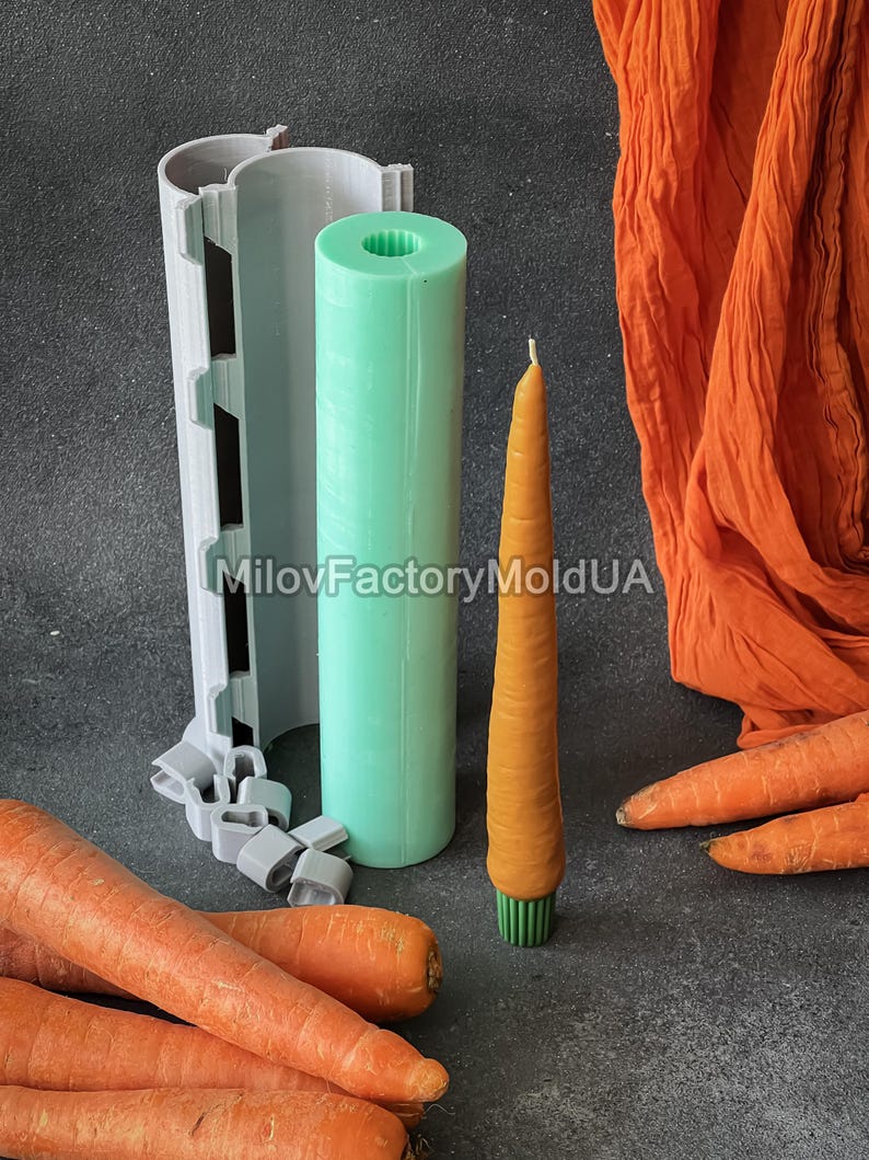 May include: A carrot-shaped candle in orange with a green base, alongside a green cylindrical mould and a grey mould. Fresh carrots and orange fabric are also in the image. The text "MilovFactoryMoldUA" is visible.