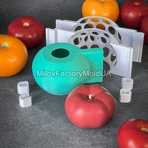 May include: A set of silicone molds for making tomato-shaped candles. The molds are teal, white, and clear. There are also several red and orange tomato-shaped candles.