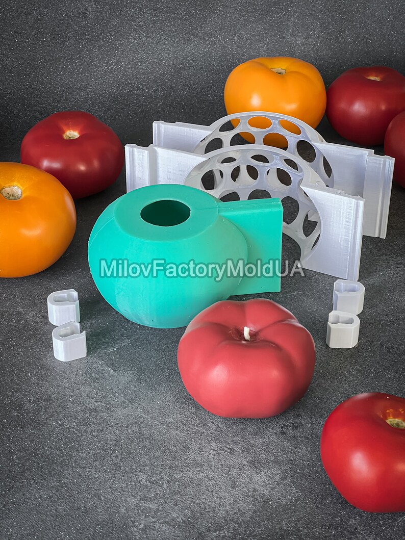 May include: A set of silicone molds for making tomato-shaped candles. The molds are teal, white, and clear. There are also several red and orange tomato-shaped candles.