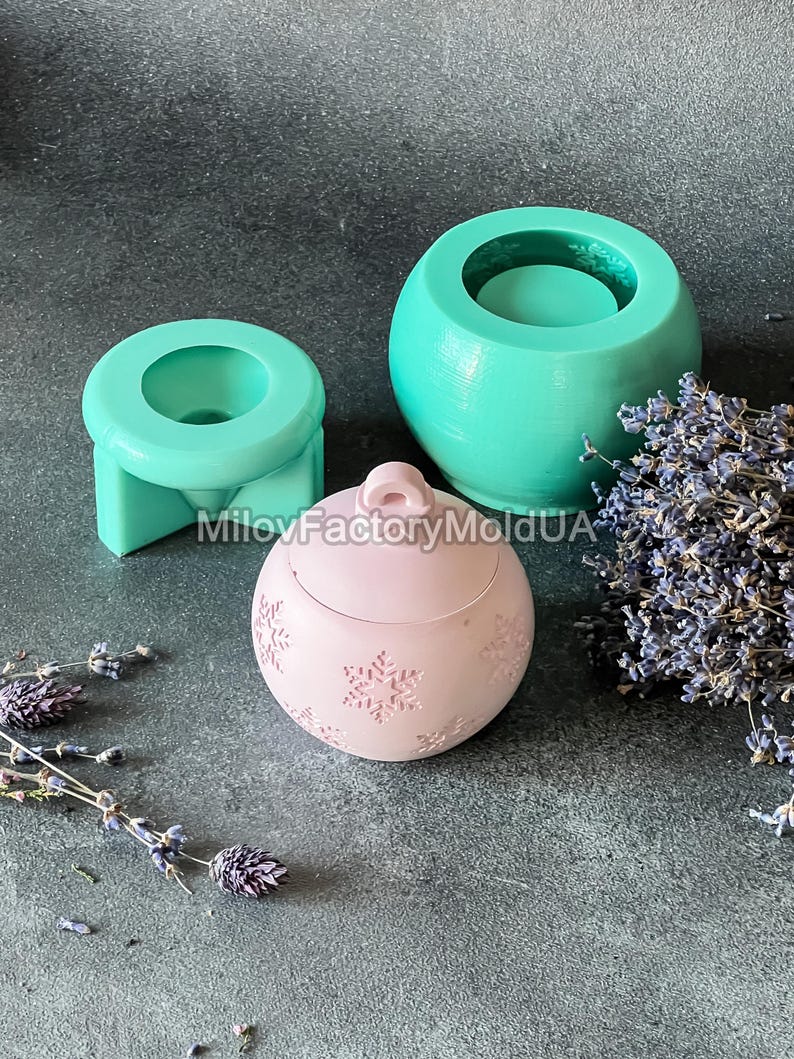Pu&ograve; includere: Tre stampi in silicone per la realizzazione di candele. Gli stampi hanno la forma di un barattolo rotondo, un piccolo barattolo rotondo e un ornamento natalizio. Lo stampo dell'ornamento ha un motivo a fiocco di neve. Gli stampi sono verdi e rosa.