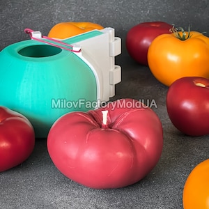 May include: A set of silicone molds for making tomato-shaped candles. The molds are shown with red, yellow, and green candles, as well as a white plastic mold.