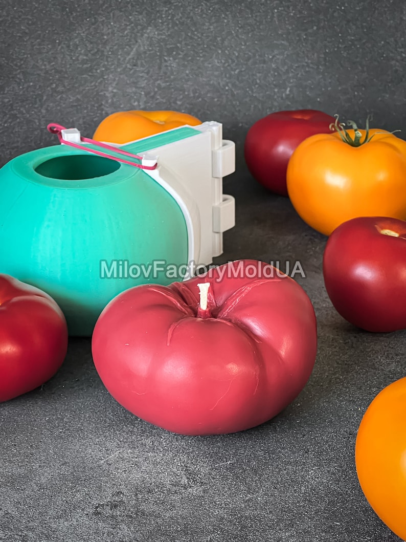 May include: A set of silicone molds for making tomato-shaped candles. The molds are shown with red, yellow, and green candles, as well as a white plastic mold.