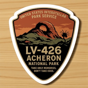Może przedstawiać: Naklejka z motywem tarczy przedstawiająca krajobraz z górą i unikalną rośliną. Tekst brzmi "UNITED STATES INTERSTELLAR PARK SERVICE" i "LV-426 ACHERON NATIONAL PARK". Na dole napis "TAKE ONLY MEMORIES, DON'T TAKE EGGS."