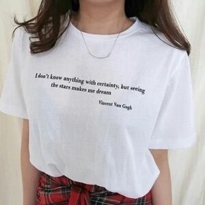Puede incluir: Camiseta blanca con una cita de Vincent Van Gogh: "No sé nada con certeza, pero ver las estrellas me hace soñar."