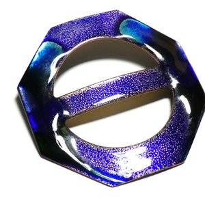 May include: A blue and green octagonal ceramic belt buckle with a shiny, speckled finish.