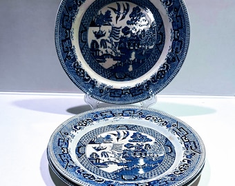 May include: Three blue and white porcelain plates with a willow pattern design. The plates are stacked on top of each other.