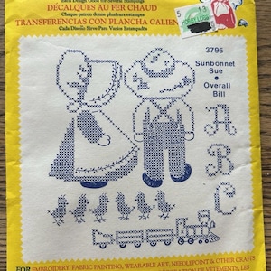 May include: A yellow Aunt Martha's hot iron transfer packet featuring blue cross-stitch style designs of Sunbonnet Sue, Overall Bill, the letters A, B, and C, small birds, and a train. The packaging includes text in English, French, and Spanish.
