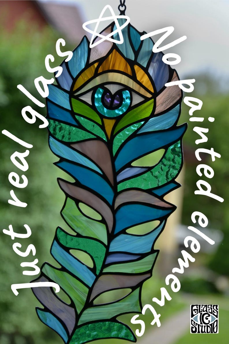 May include: A stained glass peacock feather design with an eye at the top, featuring shades of blue, green, and brown. The text reads "Just real glass" and "No painted elements". The Glass G Studio logo is at the bottom.