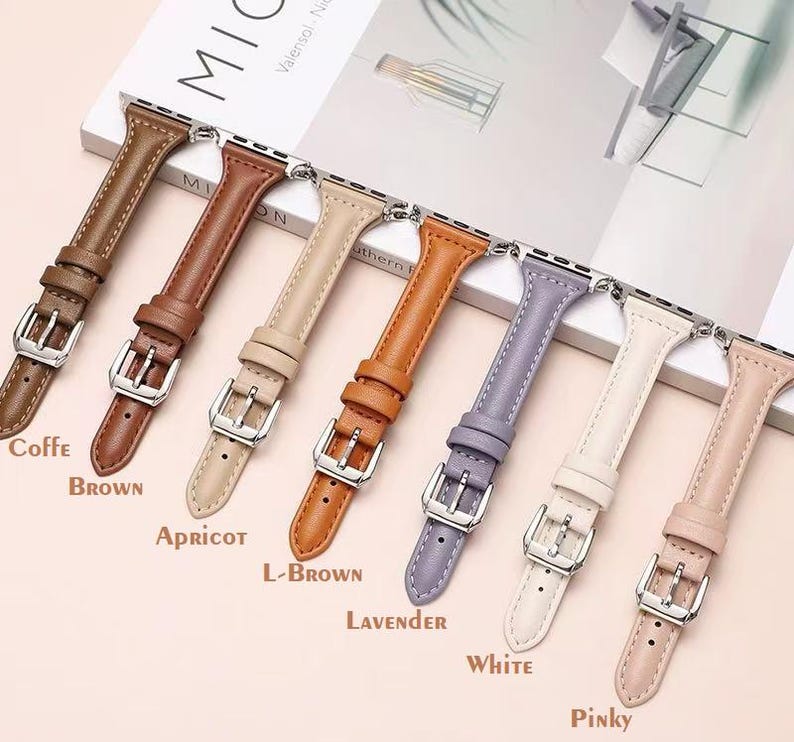 May include: Eight different colored leather watch bands for an Apple Watch. The bands are in the colors coffee, brown, apricot, light brown, lavender, white, and pinky.