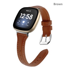 Könnte beinhalten: Ein braunes Lederarmband mit einer silbernen Schnalle. Das Armband ist kompatibel mit einer Smartwatch mit quadratischem Zifferblatt. Das Zifferblatt zeigt die Uhrzeit, das Datum und die Herzfrequenz an.