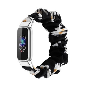 Op de afbeelding: Een zilveren fitnesstracker met een zwart-witte band met bloemenprint. Het scherm van de tracker toont de tijd, 12:58, en een hartslag van 78.