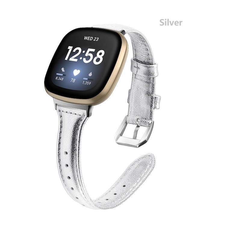 May include: A silver leather watch band with a gold-colored smartwatch face displaying the time 12:58 and the date WED 23. The watch face also shows heart rate, steps, and calories burned.