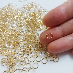 May include: A large quantity of small, gold-colored jump rings. The rings are about 6 mm in diameter and are perfect for jewelry making.