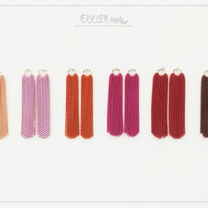 May include: Set of six pairs of long tassel earrings in various colors, including peach, lavender, orange, pink, red, and brown. The earrings are made of metal chains.