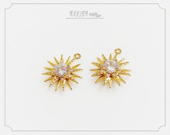 May include: Two gold-tone starburst charms with clear crystal accents. Each charm has a loop for attaching to jewelry.