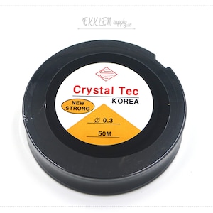 May include: A black spool of Crystal Tec brand fishing line from Korea. The spool is labelled "New Strong" and has a diameter of 0.3 mm and a length of 50 metres.