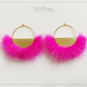 May include: A pair of gold hoop earrings with a pink fur trim. The hoops are half-covered with a gold metal sheet.