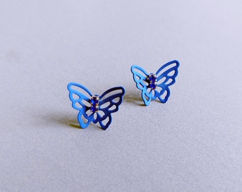 May include: A pair of blue butterfly earrings with small blue rhinestones in the center of each butterfly.