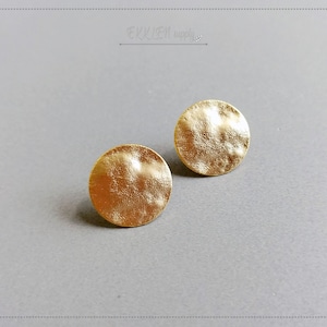 May include: A pair of gold-toned round stud earrings with a hammered texture.
