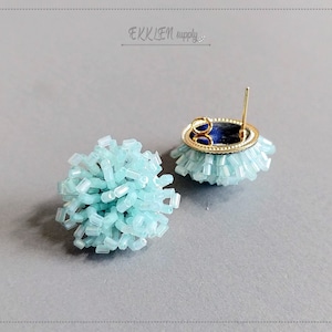 May include: A pair of light blue beaded earrings with gold posts. The earrings are round and have a fluffy texture.