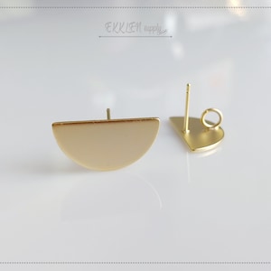 Puede incluir: Un par de postes de pendientes de tono dorado con un diseño de medio círculo. Los postes de pendientes tienen un bucle en la parte superior para sujetarse a un gancho.