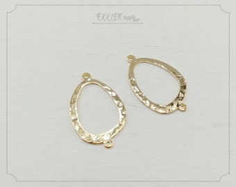 May include: Two gold-toned metal oval-shaped pendant charms with a hammered texture and three jump rings.