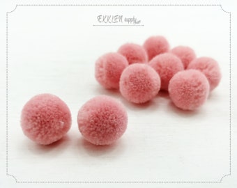 May include: A group of ten pink fluffy pom poms. The pom poms are about 1 inch in diameter.